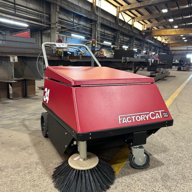 FactoryCat Walk Behind Floor Sweepers 34 production areas concrete - https://assets.factorycat.com/demoImages/2025/april/34-Walk Behind Floor Sweepers-production areas-concrete-USA-437.jpg - 800 - 800 - 437 Model 34 FactoryCat battery floor sweeper cleaning a concrete floor in the production area of a steel fabrication shop.