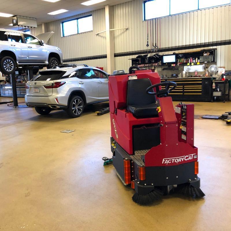 FactoryCat Ride On Floor Scrubbers GTX service bay tile floors - https://assets.factorycat.com/demoImages/2025/april/GTX-Ride On Floor Scrubbers-service bay-tile floors-Baltimore-USA-811.jpg - 800 - 800 - 811 GA FactoryCat GTX Ride On Floor Scrubber cleaning the tile floor of the service bay at a Baltimore, Maryland auto dealer