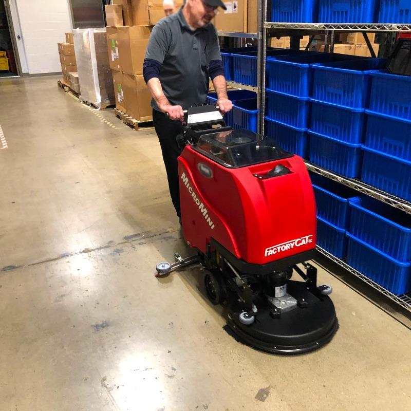 FactoryCat Walk Behind Floor Scrubbers MicroMini warehouse concrete - https://assets.factorycat.com/demoImages/2025/april/MicroMini-Walk Behind Floor Scrubbers-warehouse-concrete-lPONG bEACH-USA-853.jpg - 800 - 800 - 853 A FactoryCat MicroMini Walk Behind Floor Scrubber cleaning the concrete floor of a warehouse of a Long beach, California contract manufacturer