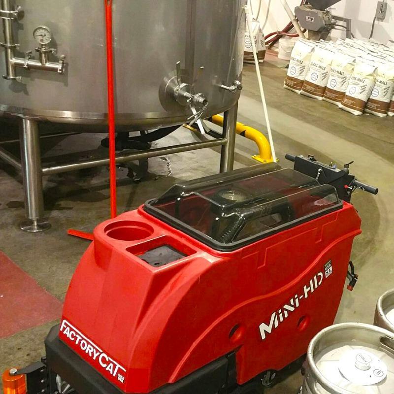 FactoryCat Walk Behind Floor Scrubbers Mini-HD production areas concrete - https://assets.factorycat.com/demoImages/2025/april/Mini-HD-Walk Behind Floor Scrubbers-production areas-concrete-Green Bay -USA-568.jpg - 800 - 800 - 568 A FactoryCat Mini-HD walk behind auto scrubber cleans the concrete floor at a brewery in Green Bay, WI