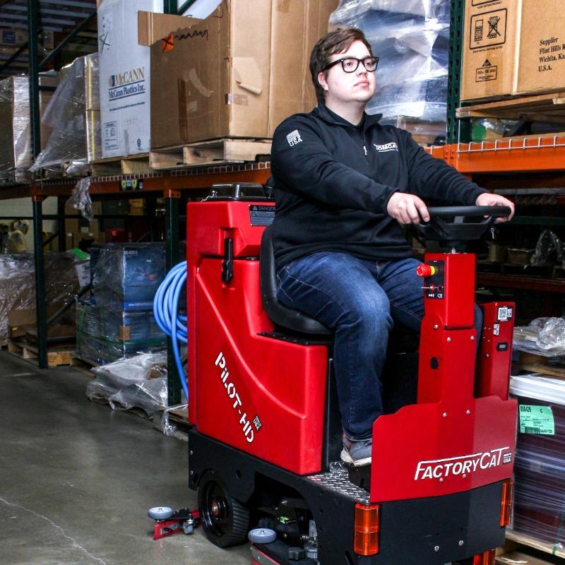 FactoryCat Ride On Floor Scrubbers Pilot warehouse concrete - https://assets.factorycat.com/demoImages/2025/april/Pilot-Ride On Floor Scrubbers-warehouse-concrete-Waco-USA-846.jpg - 800 - 800 - 846 A FactoryCat Pilot Ride On Floor Scrubber cleans the concrete aisles in a Waco, Texas fabrication shop warehouse