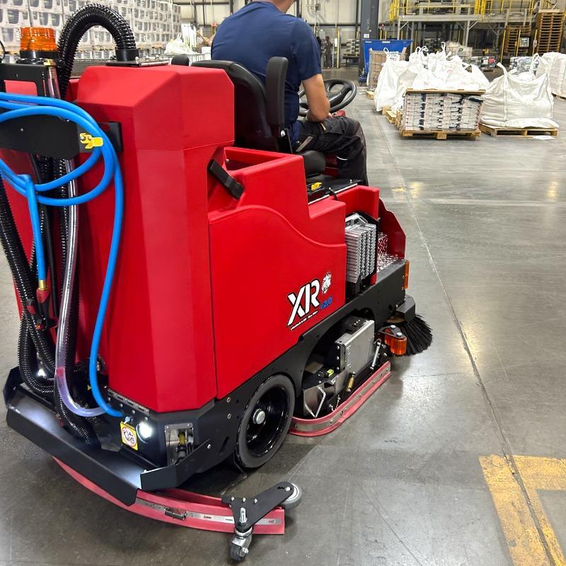 FactoryCat Ride On Floor Scrubbers XR warehouse concrete - https://assets.factorycat.com/demoImages/2025/april/XR-Ride On Floor Scrubbers-warehouse-concrete-Houston -USA-475.jpg - 800 - 800 - 475 A FactoryCat XR battery rider floor scrubber is cleaning the concrete floor of a chemical plant in Houston, TX